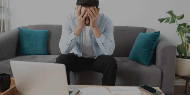Person sitting in front of laptop after losing money